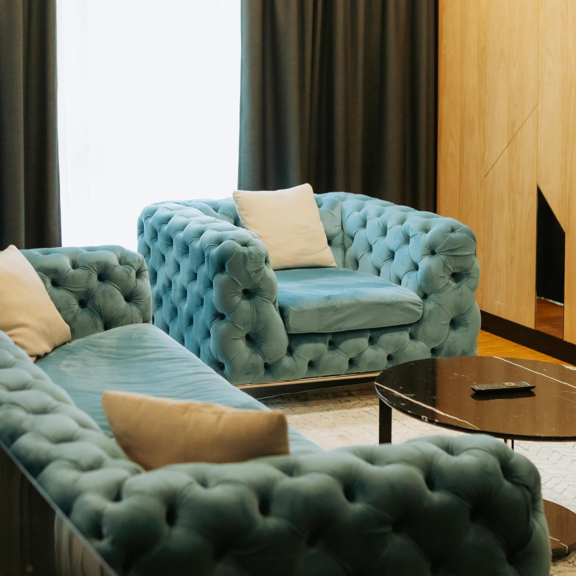 Hotel Platinia Cluj-Napoca Eksteriør billede A blue velvet Chesterfield sofa